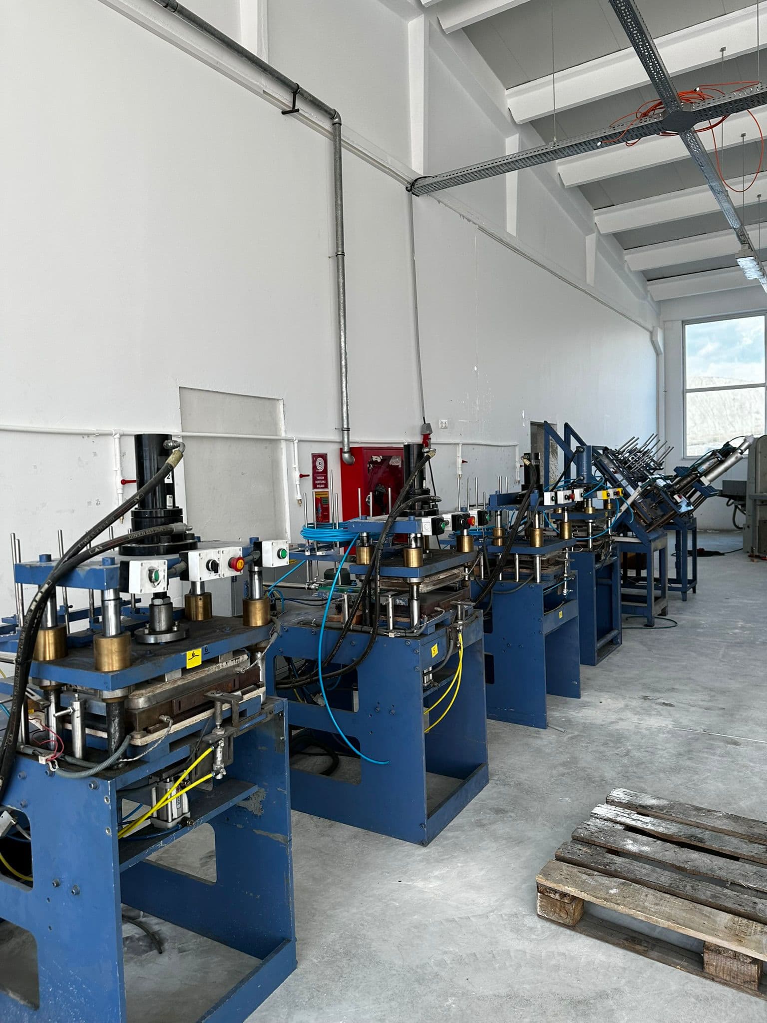 Kabelgoten en machinevoeding in een productiehal